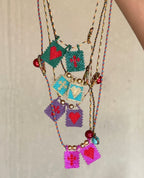 Colorful beaded necklaces with heart and flag charms on a neutral background